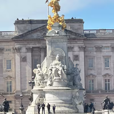 Victoria Memorial statue in front of Buckingham Palace in London under a blue sky