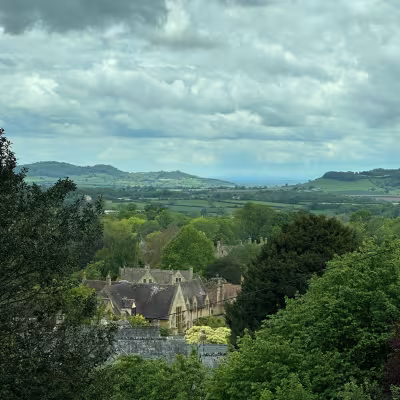 Quaint village nestled among rolling green hills and trees in the English countryside