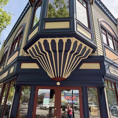 Colorful historic storefront with bold navy and cream trim and large bay windows in a small town