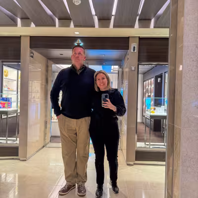 Guests posing for a mirror photo in an elegant Explora Journeys onboard shopping area