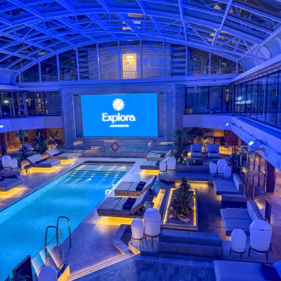 Explora Journeys covered pool deck illuminated at night