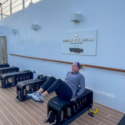 Guest using outdoor strength-training equipment at Explora Journeys Ocean Wellness fitness area