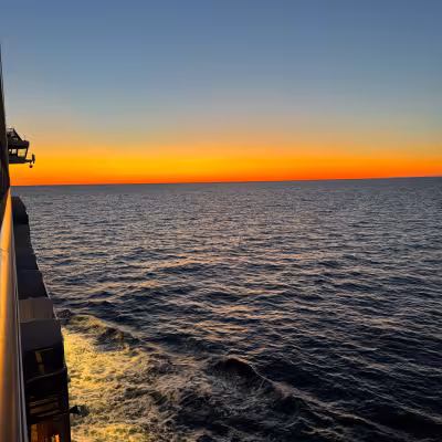 Sunset bright orange on open ocean on explora journeys