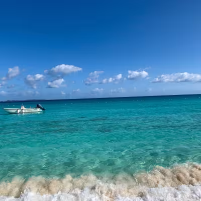 Turquoise Caribbean water and a small boat off the beach at Belmond Cap Juluca, Anguilla