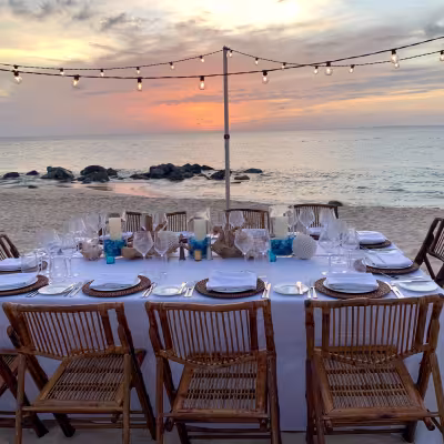 Private beachfront dinner at sunset with string lights at Belmond Cap Juluca, Anguilla