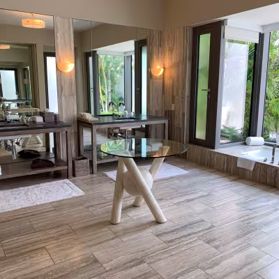 Spacious luxury bathroom with soaking tub and tropical garden views at Four Seasons Resort Anguilla