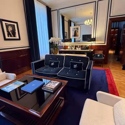Refined hotel suite living room with navy furnishings at casa cipriani Milan 