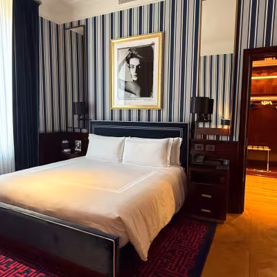 Elegant guest room with navy-striped walls at  casa cipriani Milan 