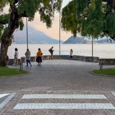 Lakeside promenade in Menaggio with views across Lake Como to the mountains