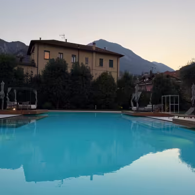 Outdoor swimming pool at dusk with mountain views at Grand Hotel Victoria, Menaggio