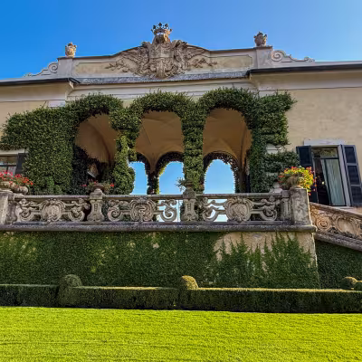 Villa del Balbianello façade with ivy-covered arches and formal gardens on Lake Como, Italy