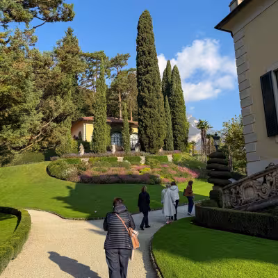 Visitors walking through manicured gardens at Villa del Balbianello on Lake Como