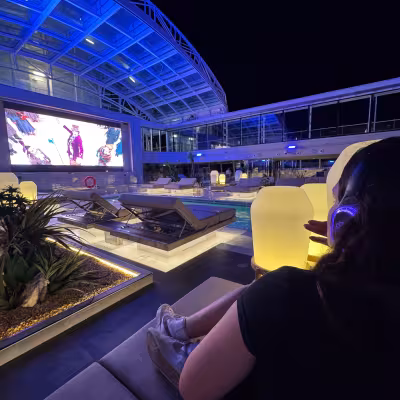 girl watching movie on outside solarium of explora I 