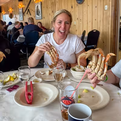 Mom holding up Dungeness crab claws at the George Inlet Lodge crab feast in Ketchikan, Alaska