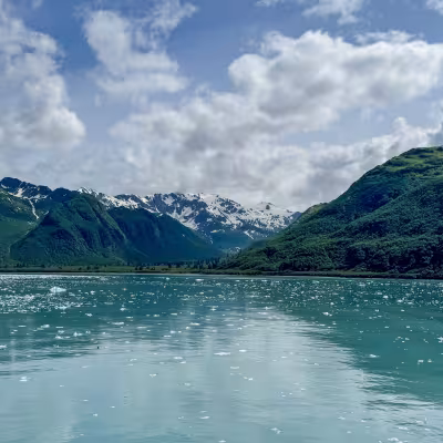 Floating glacial ice and green mountain peaks near Hubbard Glacier, Alaska