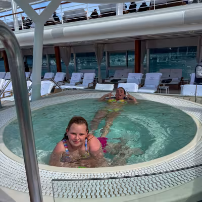 Teens relaxing in the whirlpool on Regent Seven Seas Explorer's pool deck