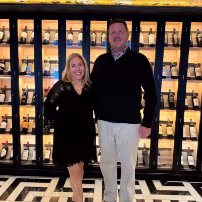Couple dressed up for formal night in front of the wine cellar aboard Regent Seven Seas Explorer