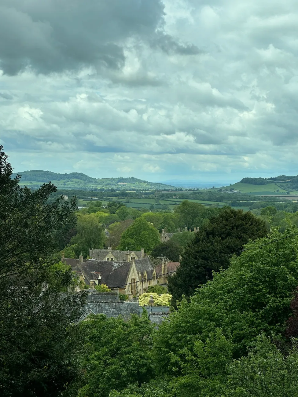 Quaint village nestled among rolling green hills and trees in the English countryside