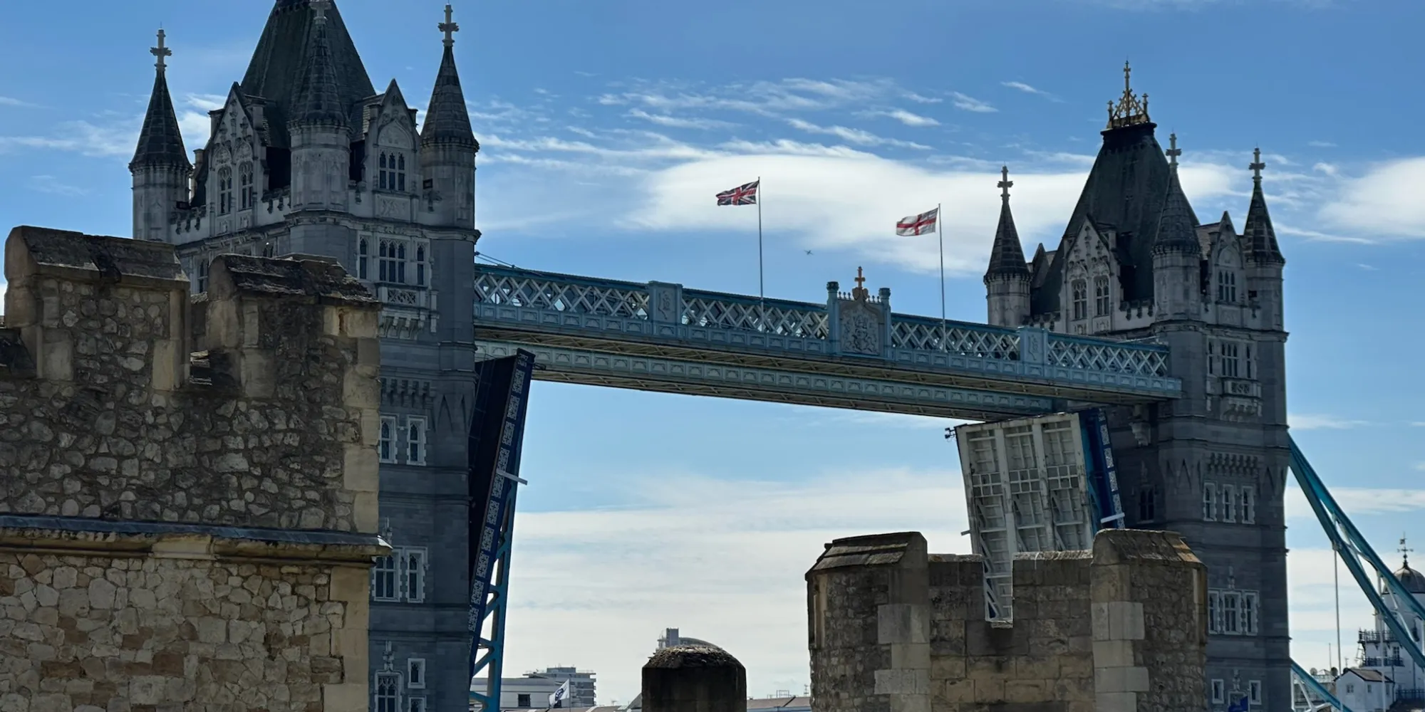 Tower Bridge in London with bascules raised, seen from historic stone ramparts